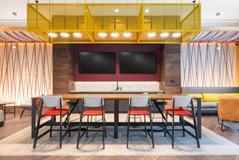 a dining room with a table and chairs and a wall with a tv at The Chase at Bryant Street, Washington